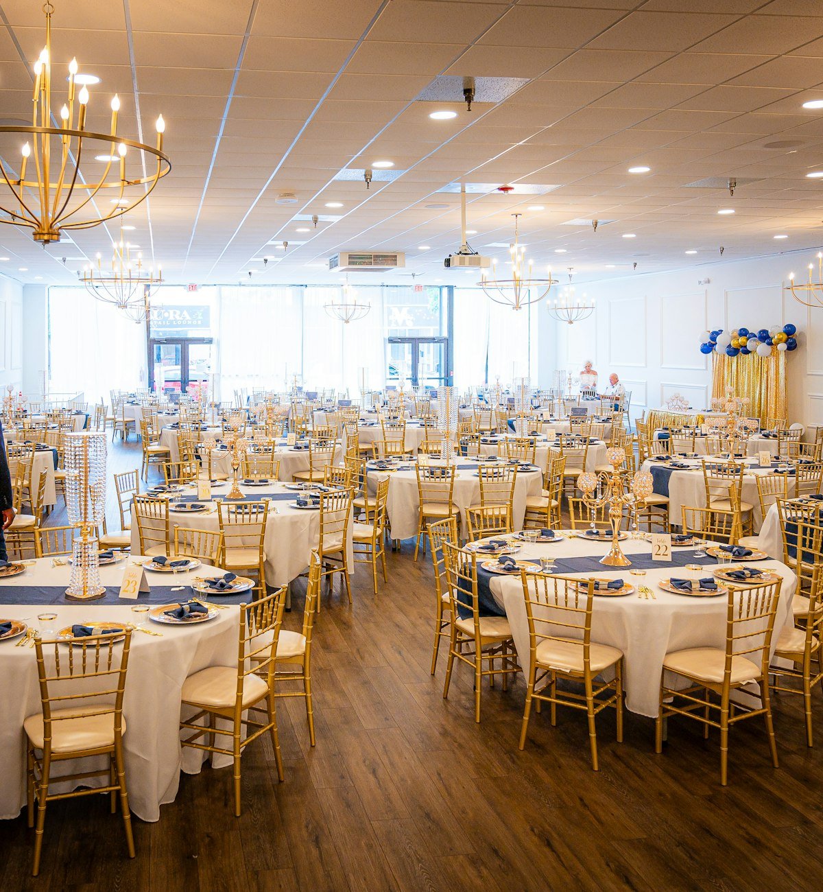 Banquet hall set with round tables under chandeliers