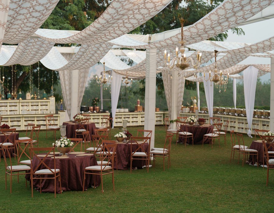 Outdoor wedding reception with draped canopies and set tables