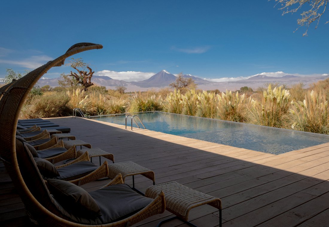 Loungers beside a pool facing distant mountains
